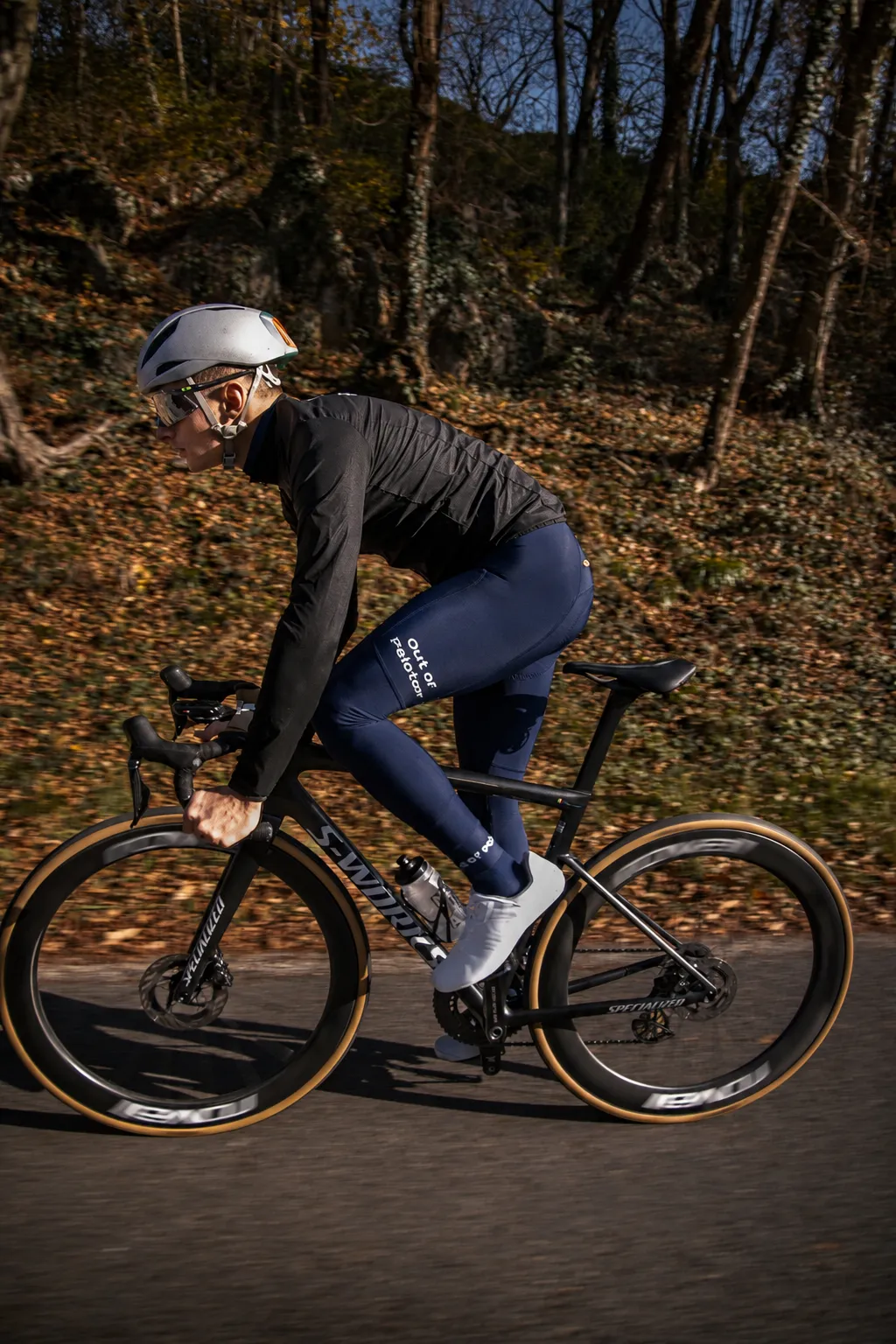 Rider in deep blue Altum Thermal Tights on a road through autumn woods